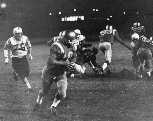 Valley College's Ron Moser chases Pasadena quarterback Bill Cravens