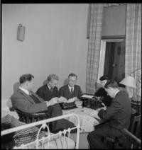 Bad Grankulla. Office, 4:00 p.m. [Men and woman of evacuated American Legation with typewriters at small table in bedroom at Bad Grankulla.]