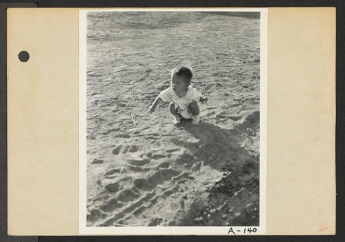 Poston, Ariz.--Little evacuee playing in the desert sand at this War Relocation Authority center for evacuees of Japanese ancestry. Photographer: Clark, Fred Poston, Arizona