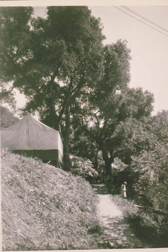 Woman standing near tents in Temescal Canyon, Calif