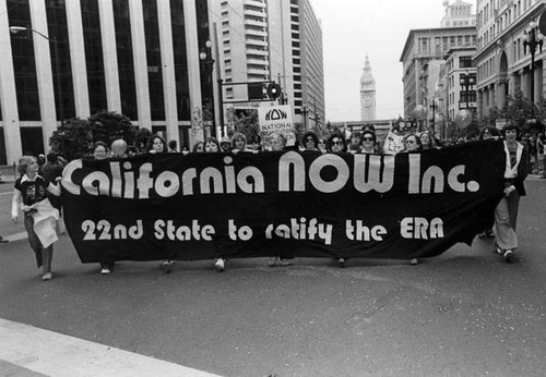 Parade participants holding a "California Now Inc." banner