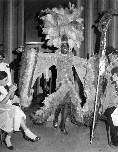 Billy DeFrank wearing a high feather headdress