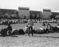 Marchers kneeling on grass with their heads down