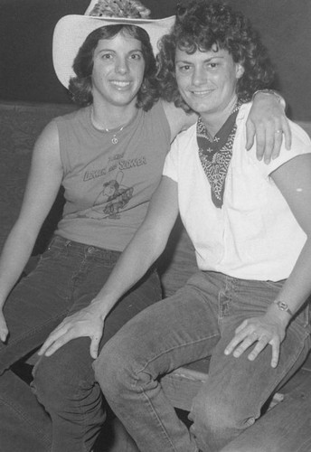 Two women pose in cowboy attire