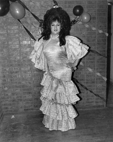 Female impersonator wearing a party dress and high wig