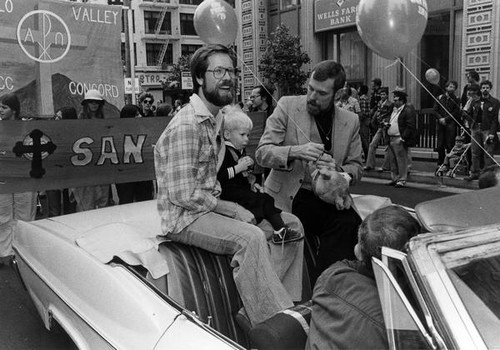 Two men with a child on a car float