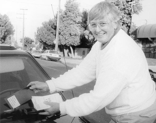 Wiggsy Sivertsen placing political fliers on a windshield