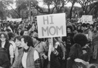 Marcher with "Hi Mom" sign