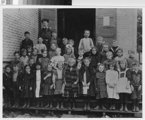 Class portrait taken on steps of "Old Tin Schoolhouse", ca. 1906-1908