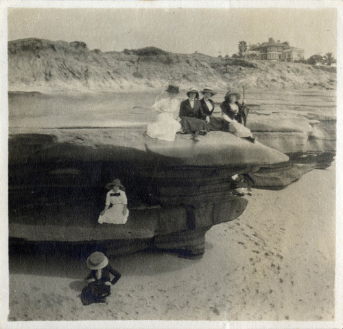 [Five women sitting on a sea cliff and one woman sitting on a beach]