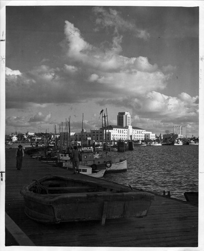 [Harbor front scene with fishing boats and the Civic Center in the background]