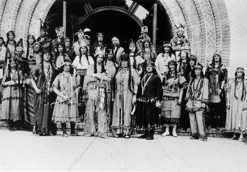 People in Native American dress in front of Tower Hall