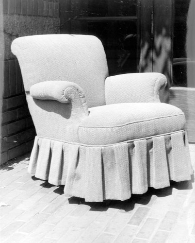 Upholstered chair with pleated skirt