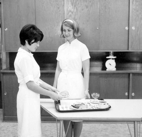 Students setting foodstuff on a tray