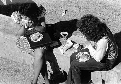 Two female students eating lunch outside