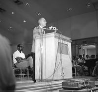 Robert D. Clark gives a speech from a podium