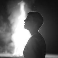 A profile of a woman in front of a fire