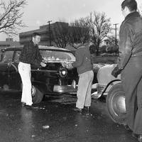 Three men scrape snow off a car