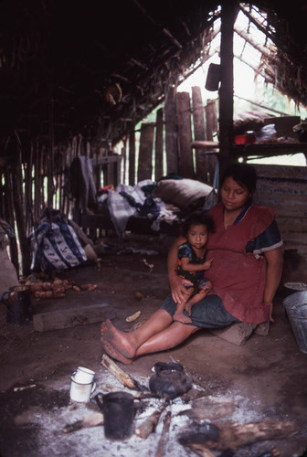 Mayan woman and child sit in a hut, Santiago el Vértice, 1983
