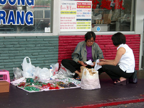 Lady selling jade and other jewelry in front of Bolsa B. B. Q. on the corner of Bolsa and Magnolia