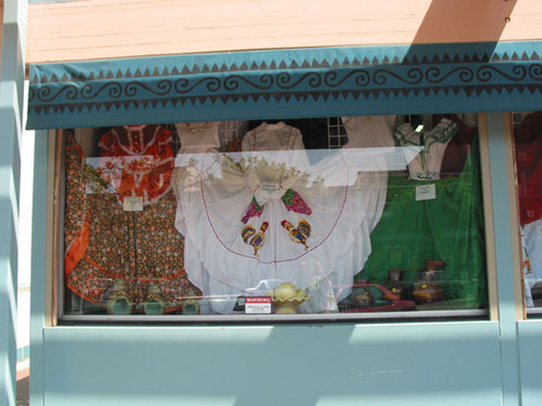 Display window at El Faisan on Fourth Street with traditional Mexican dresses, August 2002