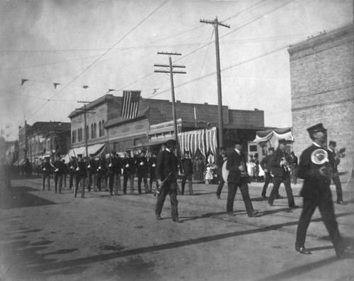 Street scene with a parade looking West from French St. at Fourth and Spurgeon St. in 1908