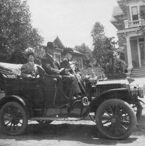 Snapshot of automobile and passengers outside Chris McNeil's home on 911 Spurgeon St