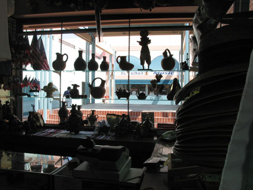 Silhouettes of earthenware and merchandise in a shop at El Faisan on Fourth Street, August 2002