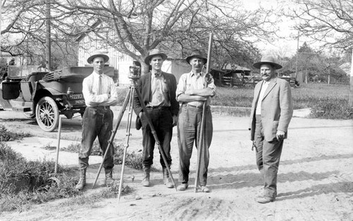 Group of men posing with surveying equipment