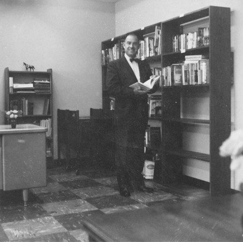 Man holding a book, perhaps at the dedication ceremonies of the Santa Ana Public Library at 26 Civic Center Plaza on May 1, 1960