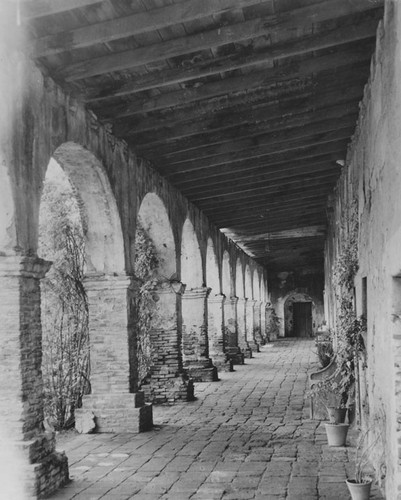 View down an arched passageway at Mission San Juan Capistrano on the corner of Ortega Highway & Camino Capistrano