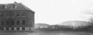 Gymnasiet i Pitsaikou med syrenbjerget i baggrunden