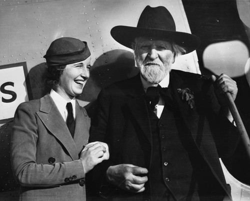 Edwin Markham [picture] : California poet with flight attendant Clara Johnson at the Oakland Municipal Airport