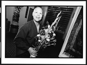 Buddhist monk of Chinese origin, holding flowers at Ling Shen Ching Tze Temple, Chicago, Illinois, 2002