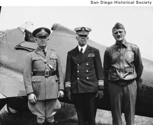 Three military officers standing in front of an airplane at Rockwell Field on North Island