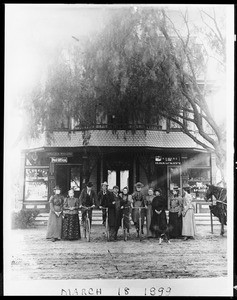 Portrait of people in front of Sackett Store, Post Office, and Hotel on the southwest corner of Cahuenga Boulevard and Hollywood Boulevard, March 18, 1899