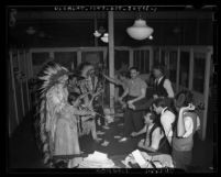 Behind the scenes at 1939 Union Station Pageant people dressed as Native American Indians holding up men in business office
