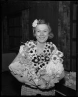 Lillian Reynolds holds an armful of artificial flowers at an exhibit of arts and crafts and hobbies, Los Angeles, 1935