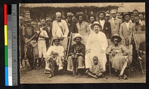 Missionary father seated with a group of men, Congo, ca.1920-1940