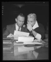 Barbara Payton holds her nose as she inspects summons with attorney Milton Golden, Los Angeles, 1955