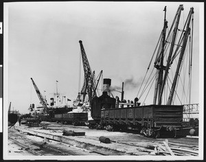 Railroad flat cars at harbor loading dock, ca.1930