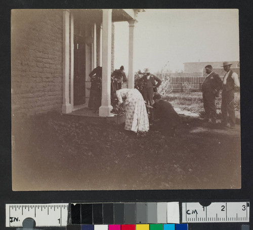 Men and women on porch of a building