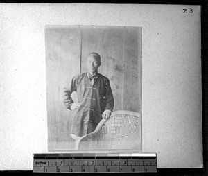 Chinese man near a chair, Fujian, China, ca.1895-1899