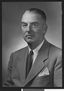 University of Southern California assistant football coach Sam Barry, posed in suit, solid tie, and handkerchief (not smiling), 1946