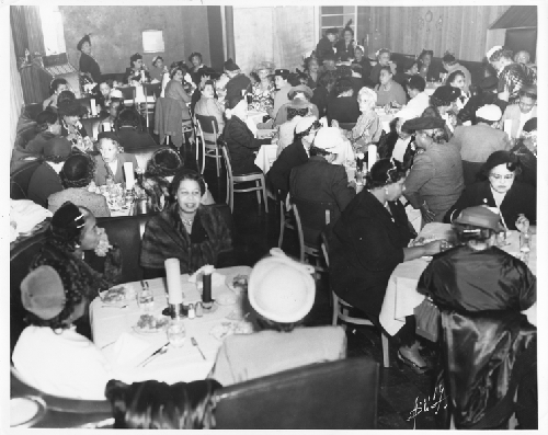 Women seated at white-cloth covered tables in Slim Jenkins Bar and Restaurant