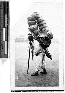Korean man carrying bundle of clay pots on his back, Korea, ca. 1920-1940