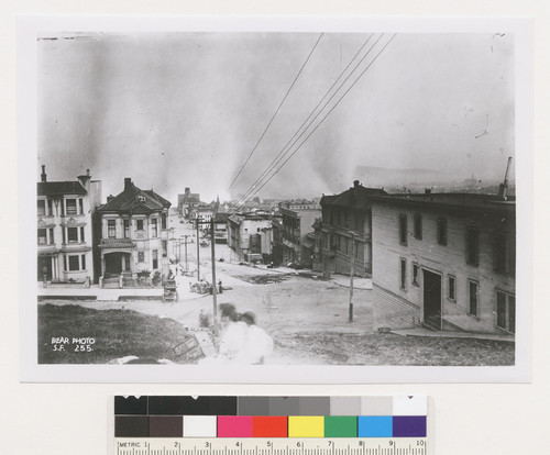 [View along unidentified street. Fire burning in distance. No. 255.]