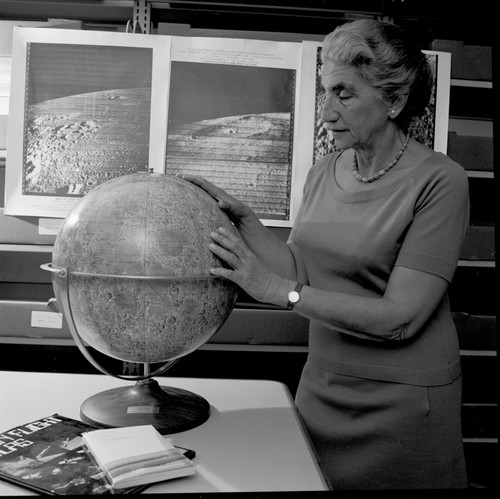Mrs. Gertrude Weiss Szilard of the UCSD School of Medicine faculty with lunar maps and moon globe indicates the lunar crater named after her late husband, Leo Szilard, who was a physicist who conceived the nuclear chain reaction and worked on the Manhattan Project. November 6, 1970