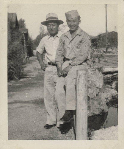 Mitsuru Yagura and man at wooden railing at Poston incarceration camp