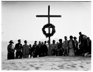 Men and women kneeling before a cross in a funeral